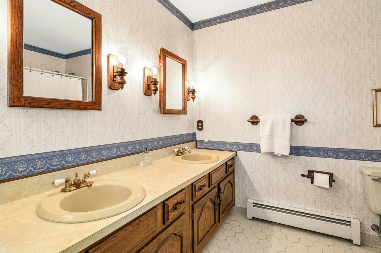 Double-sink vanity, tub-shower combination and located off the upper hall landing.