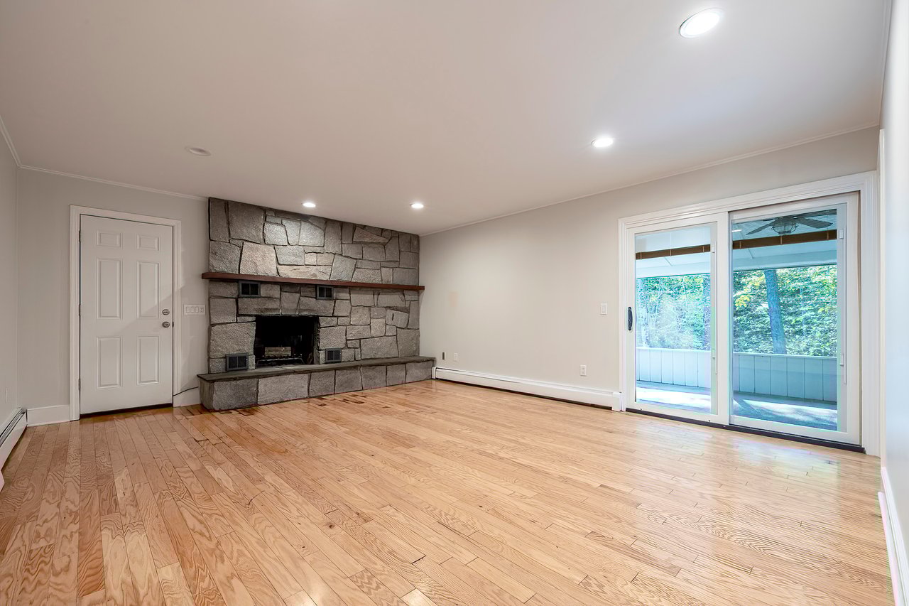 Family Room with stone wood-burning fireplace and access to screened porch	