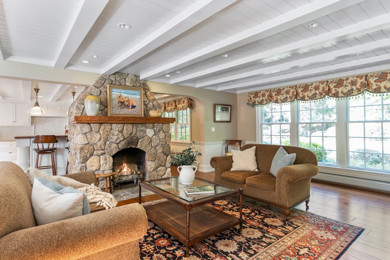 Family room with beautiful fieldstone fireplace creates a seamless space for family gatherings and entertaining
