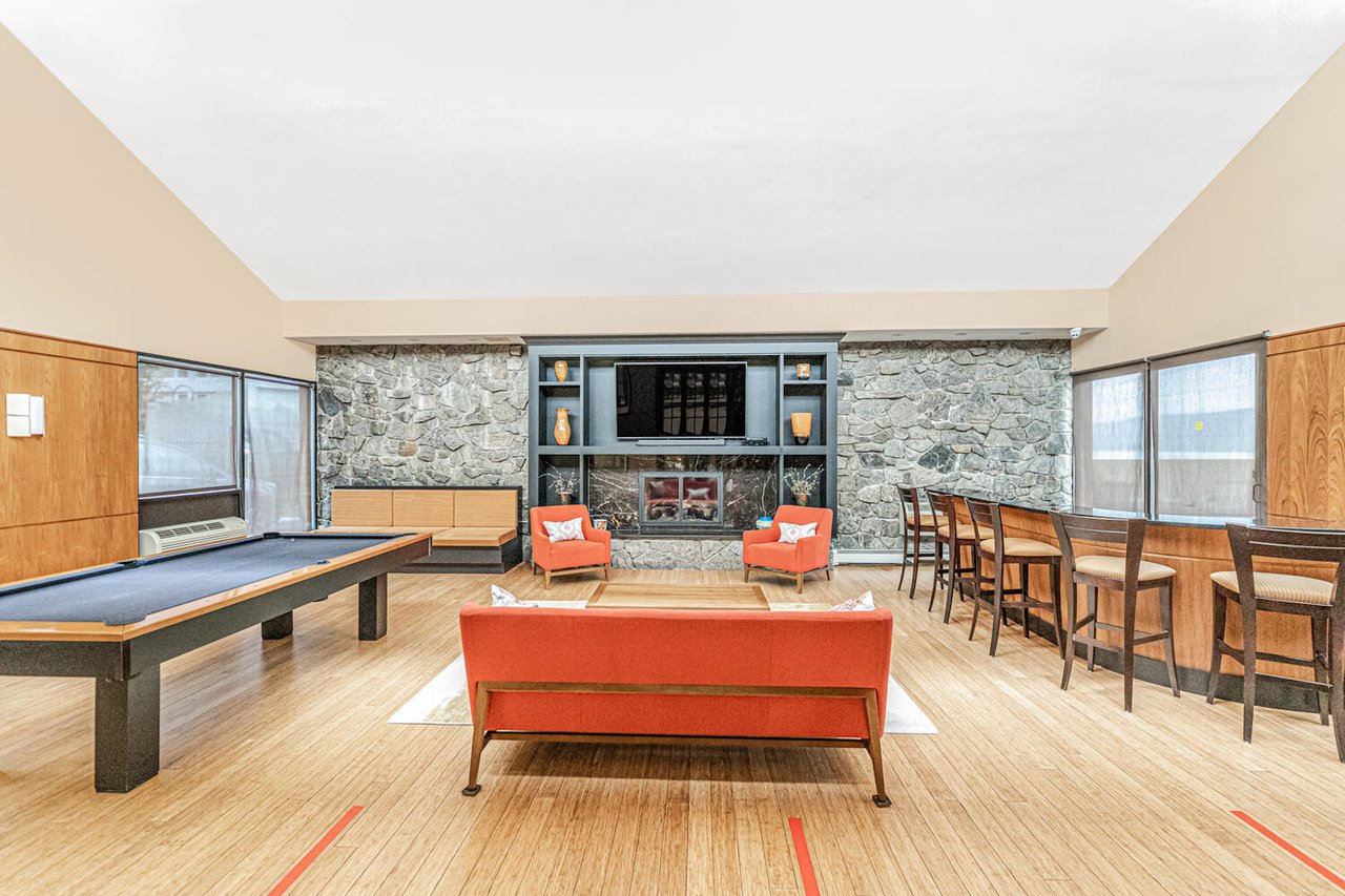 Community Room with Pool Table, Large Flatscreen TV with Cable Connected, Bar with Ice Machine and Refrigerator, Library Area, Sofa's Chairs and Tables.