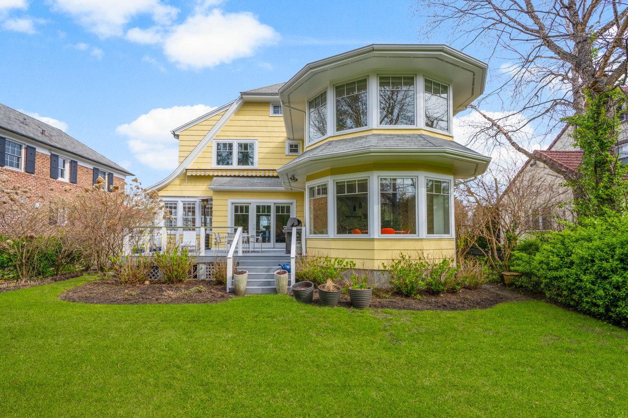 Back of property featuring a wooden deck and a yard