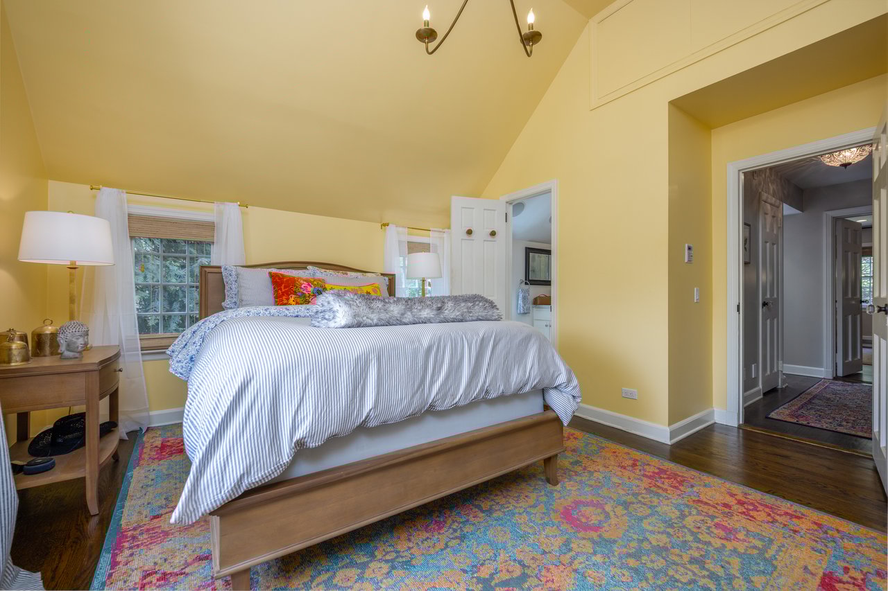 Bedroom with vaulted ceiling, wood finished floors, and baseboards