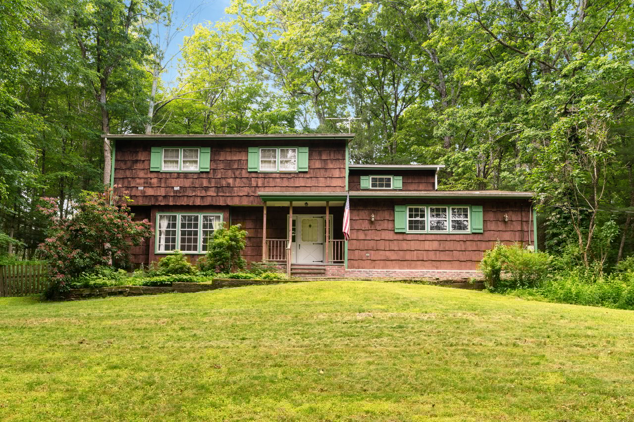 View of front of home featuring a front lawn and a porch...