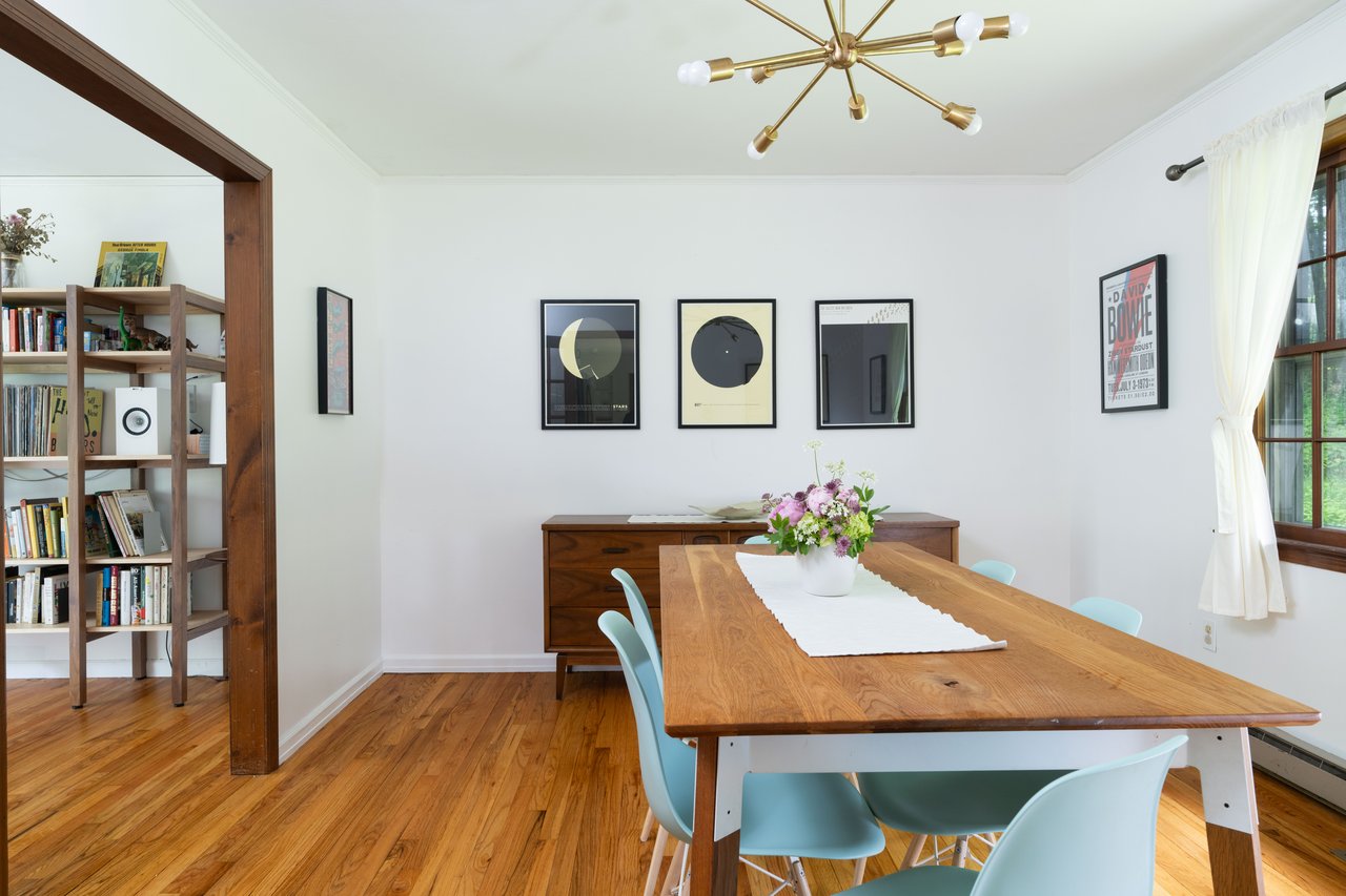 Dining area with a chandelier, light wood finished floors, baseboards, ornamental molding, and a baseboard radiator