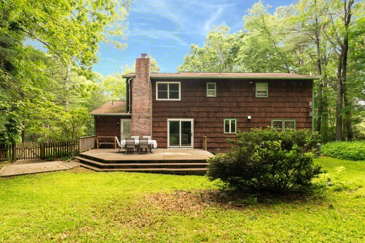 Back of property featuring a chimney and a deck