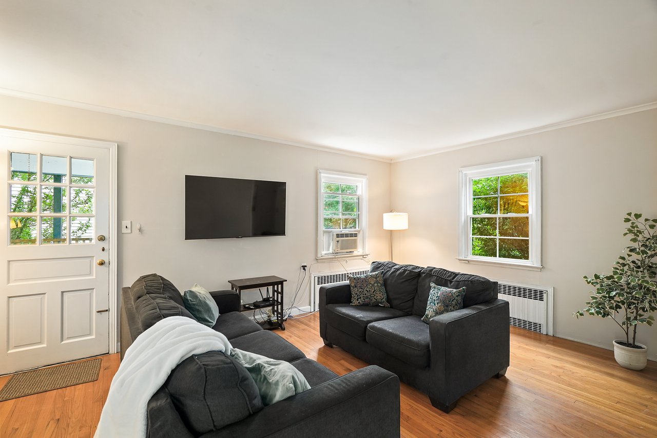 Living area featuring radiator, ornamental molding, wood finished floors,