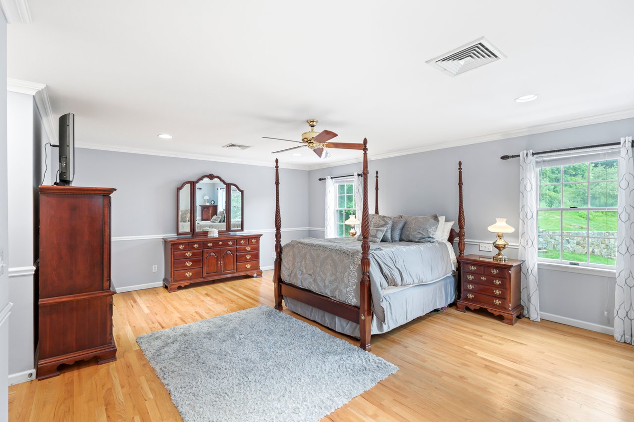 Enormous Primary Suite with wood finished floors, recessed lighting, crown molding, and ceiling fan