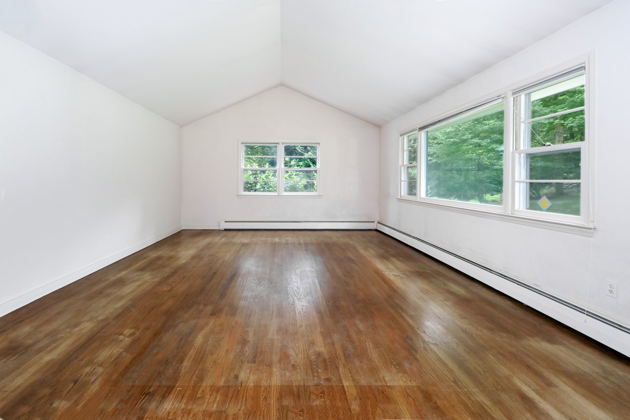 Large living room with cathedral ceiling and hardwood floor.