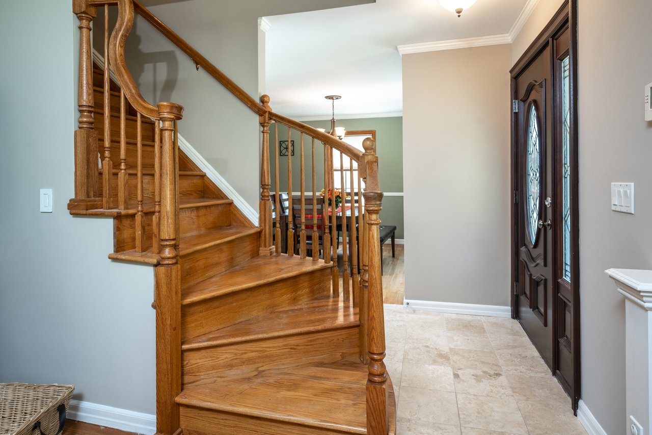 Foyer entrance with curved staircase to second floor.