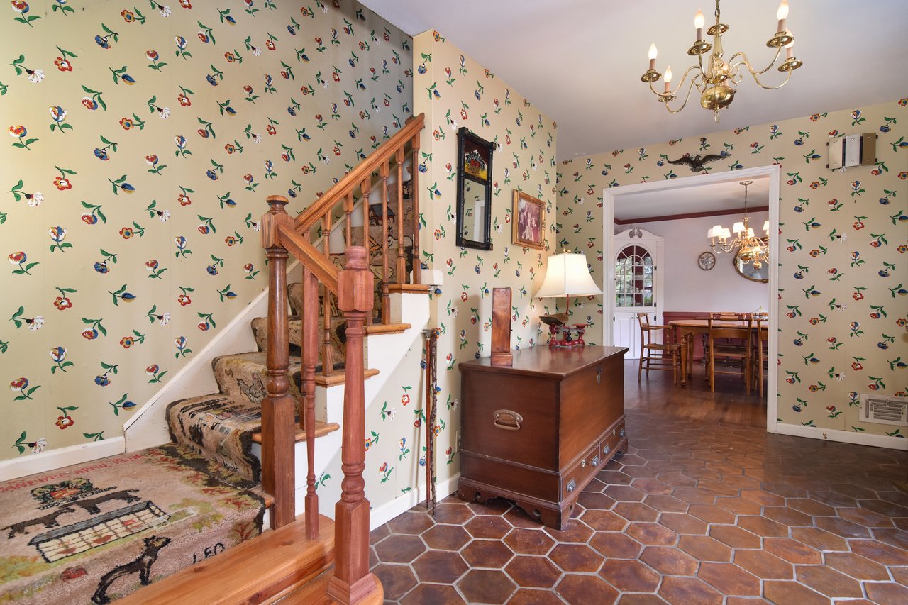 Step into a spacious entry foyer showcasing two coat closets, durable Mexican tiled flooring, and seamless access to both living and dining rooms.