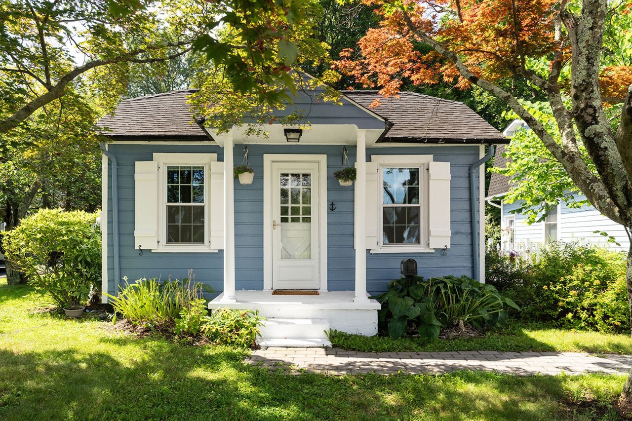 View of front of property featuring a front yard and roof with shingles