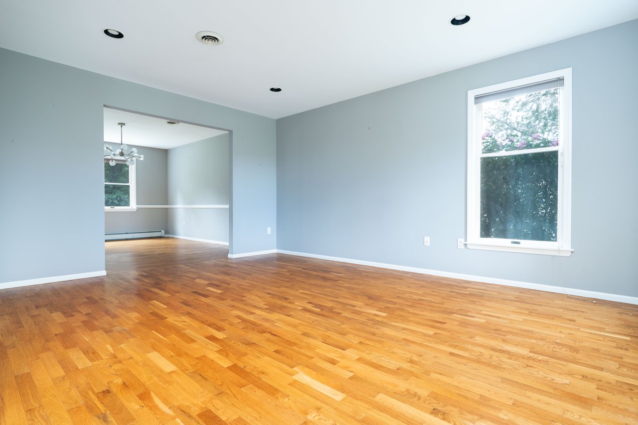Unfurnished room featuring a chandelier, light hardwood floors, and a baseboard radiator