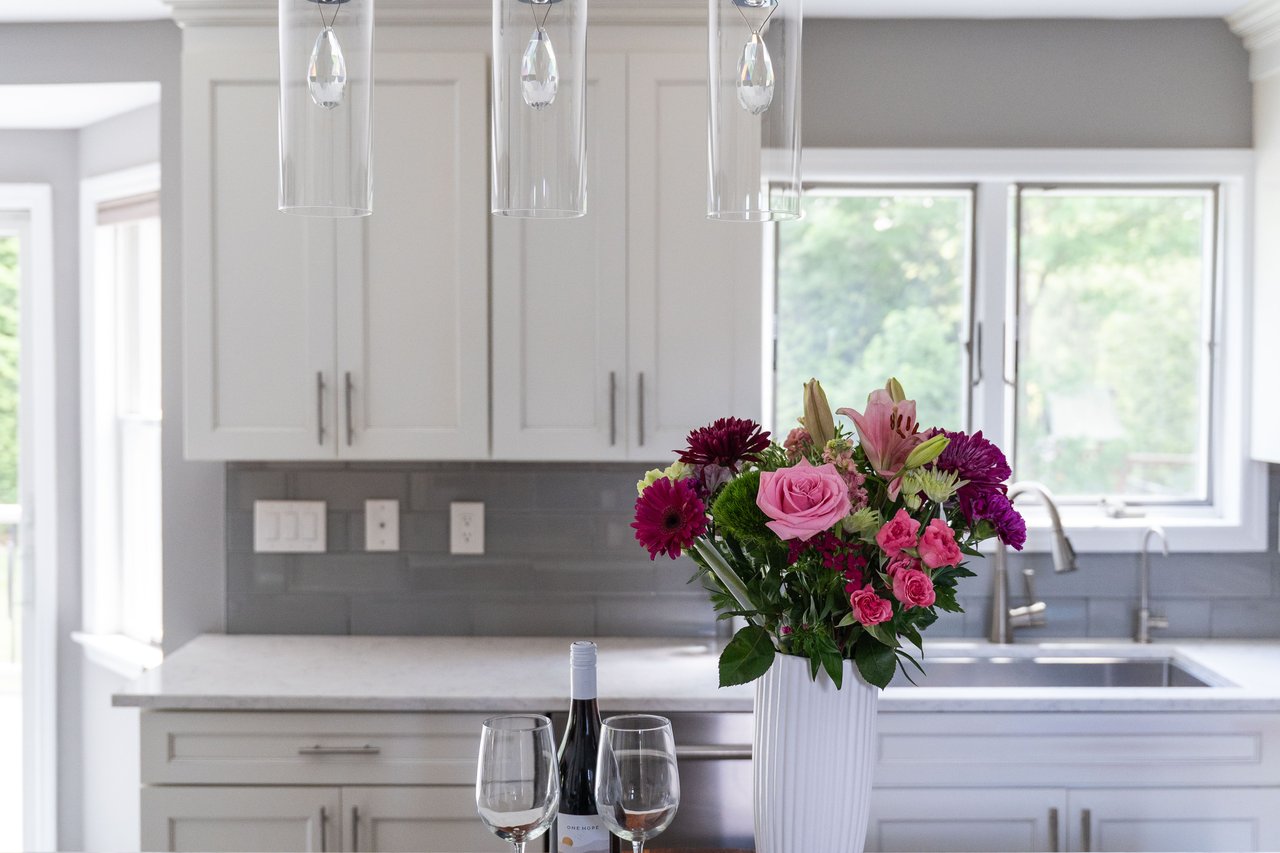 Kitchen with tasteful backsplash, healthy amount of natural light, and white cabinetry
