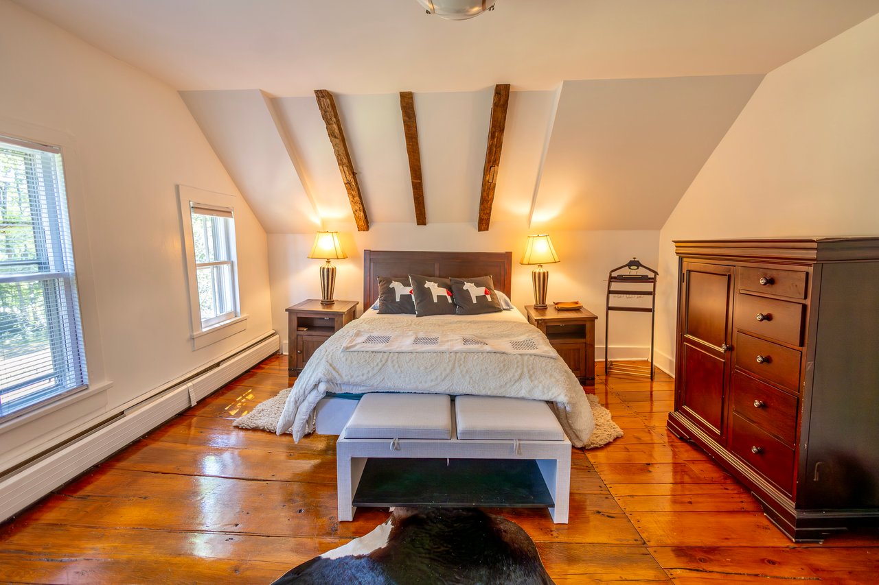 Bedroom featuring wood-type flooring and a baseboard heating unit