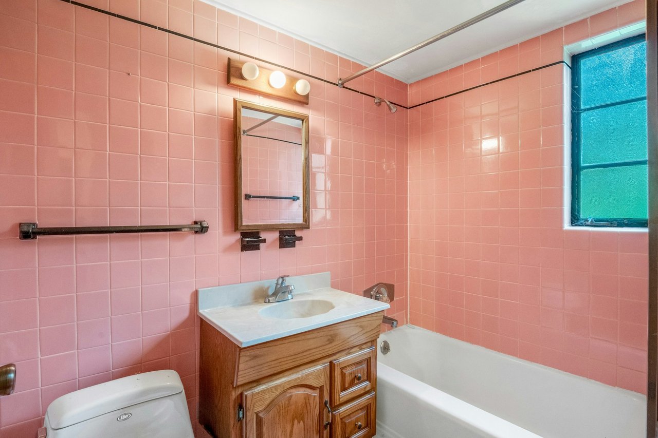 Full bathroom with tile walls, vanity, and tub / shower combination...