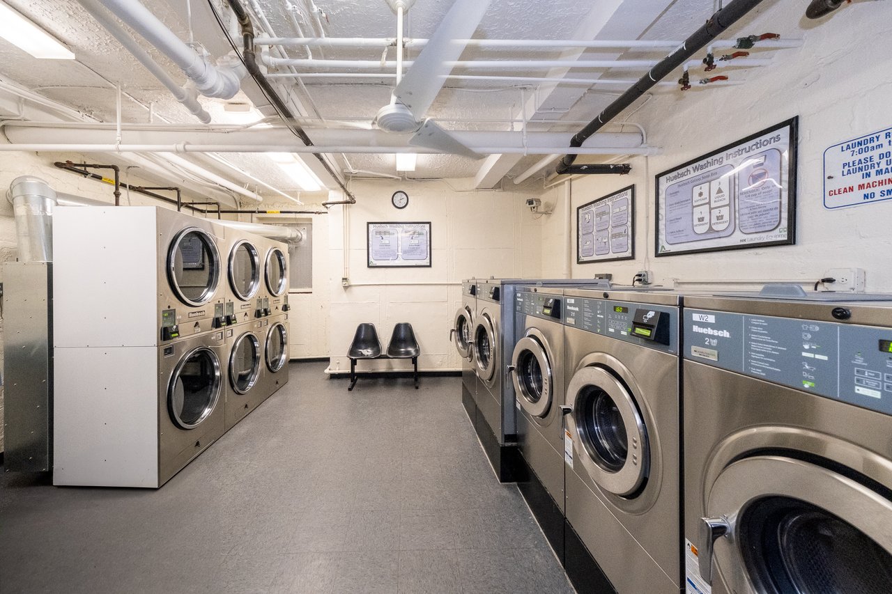 Community laundry featuring independent washer and dryer, tile patterned floors, and stacked washer / drying machine