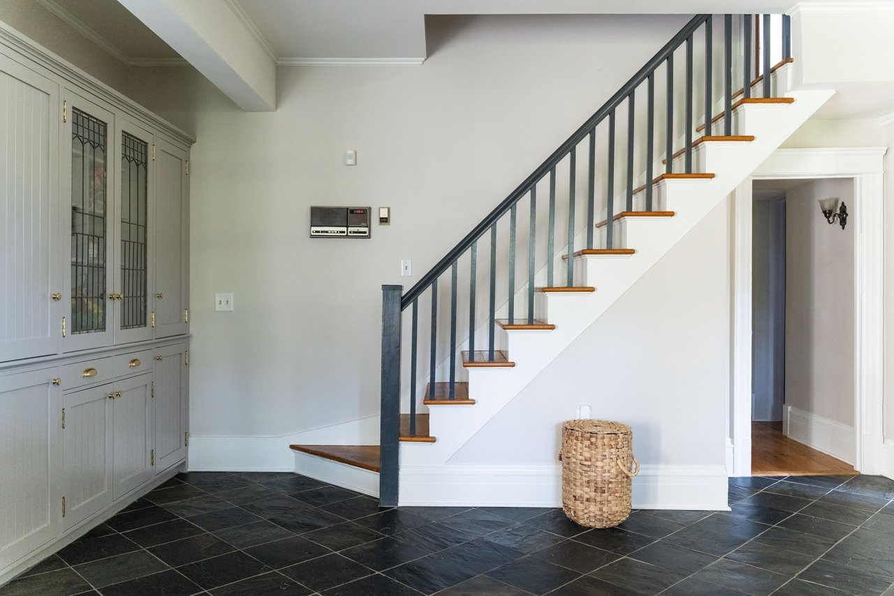 Staircase featuring ornamental molding and baseboards