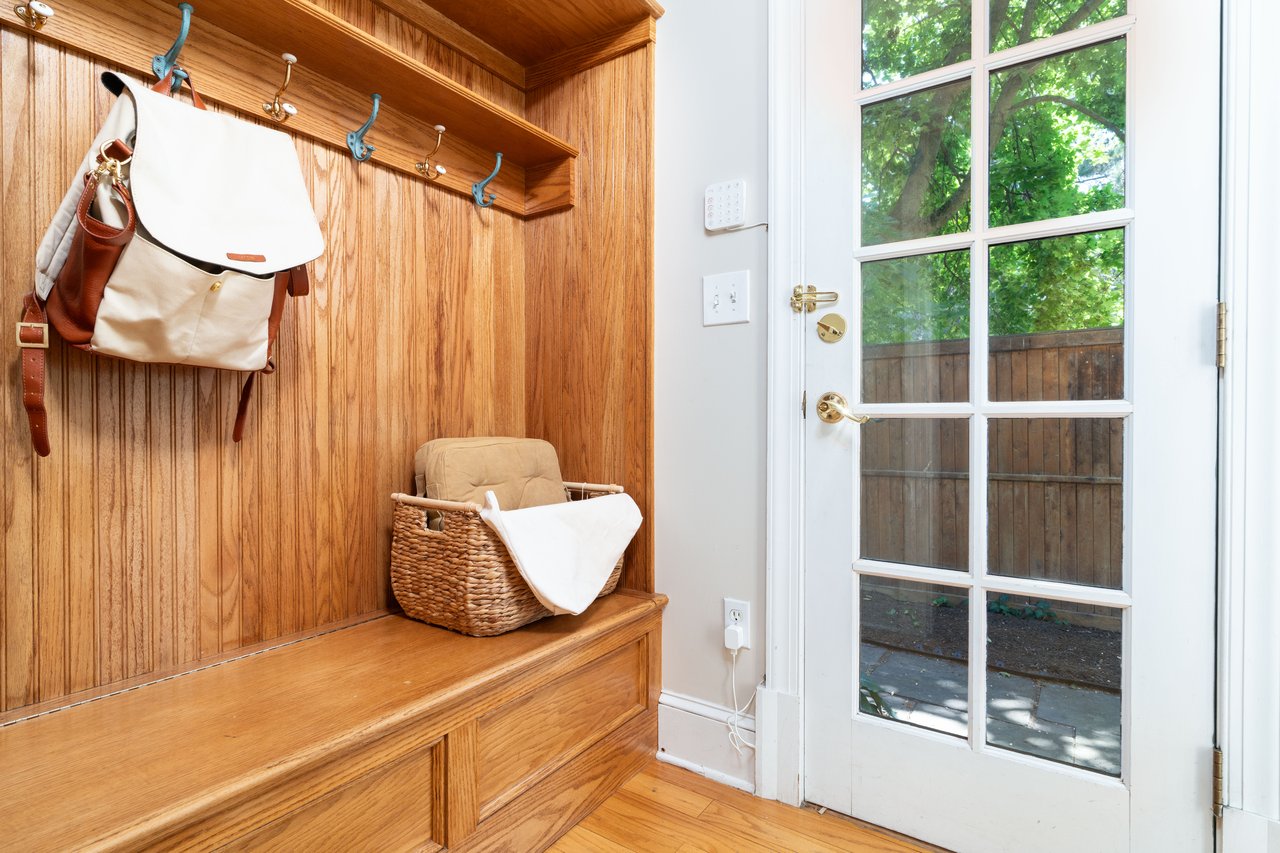 Mudroom featuring light wood-style floors and wood walls