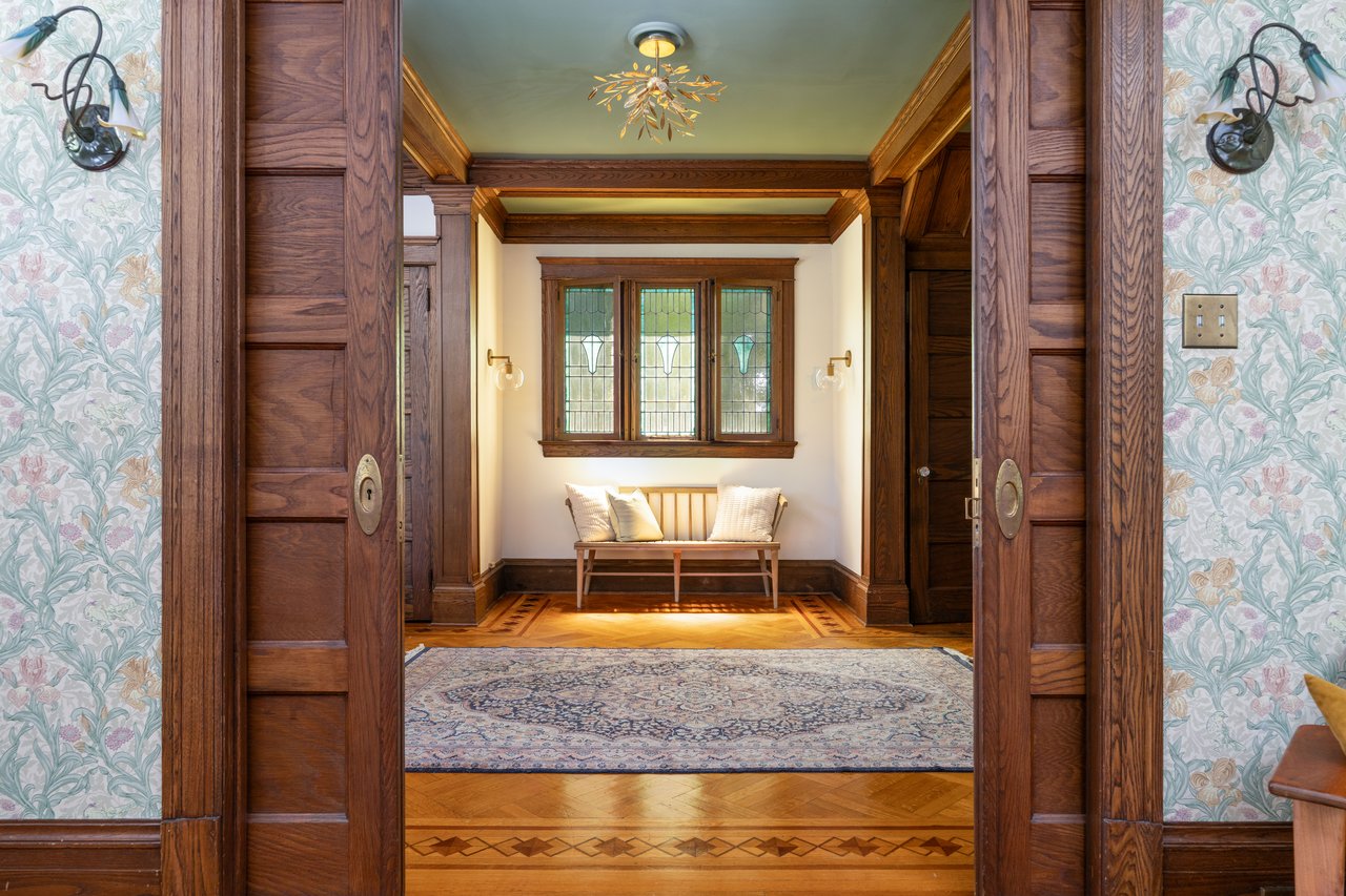 Sitting room featuring wallpapered walls and crown molding