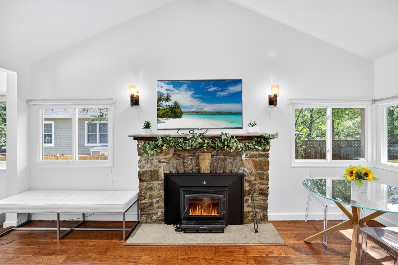 Living area featuring vaulted ceiling, wood finished floors, and plenty of natural light