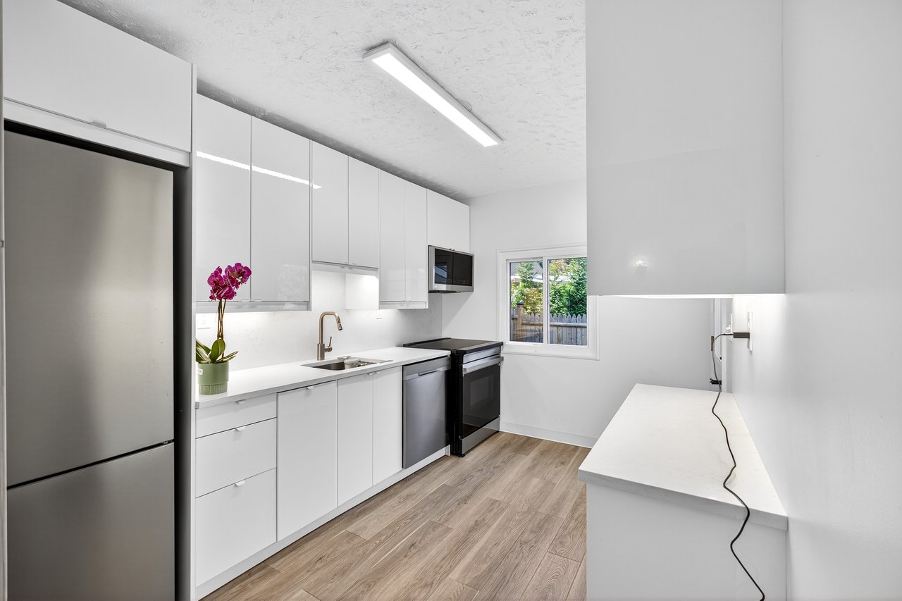 Brand New Kitchen with modern cabinets, Quartz Counters, stainless steel appliances, white cabinetry, light wood-style floors, and a textured ceiling