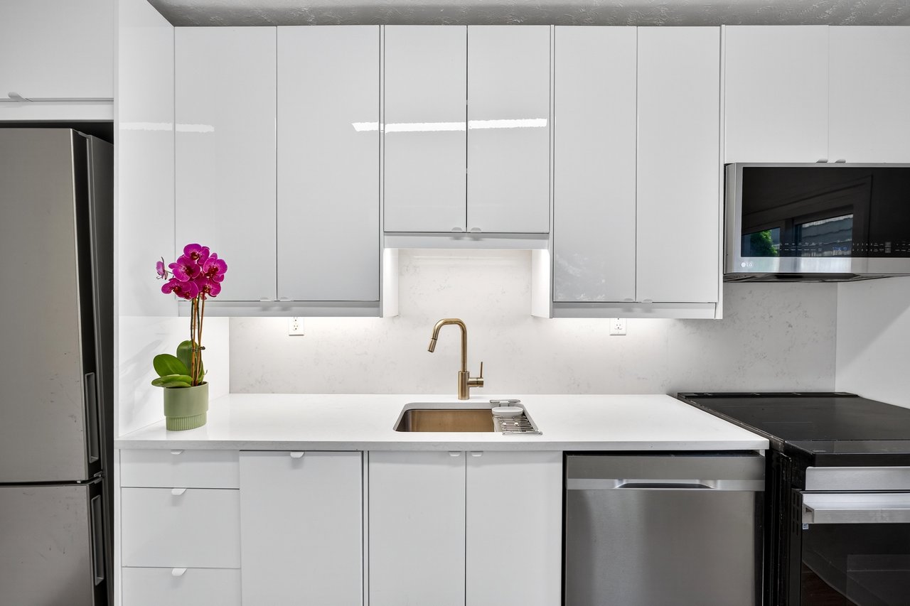 Brand New Kitchen with modern cabinets, Quartz Counters, stainless steel appliances, white cabinetry, light wood-style floors, and a textured ceiling