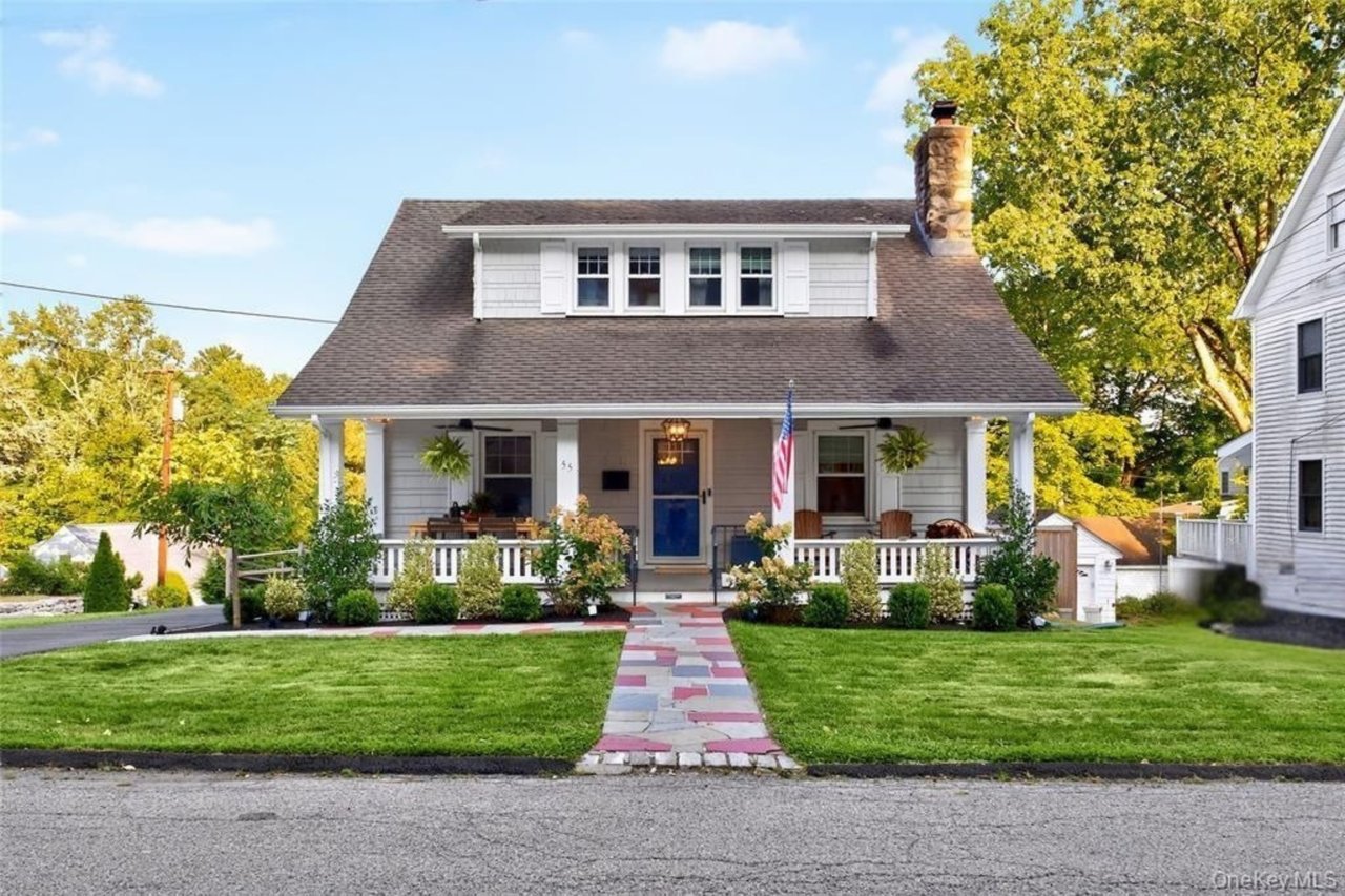 Delightful home featuring an expansive porch and beautiful perennial plantings.