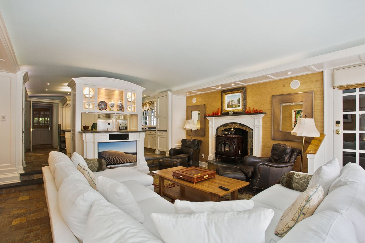 Gorgeous family room complete with built-in TV space, wood-burning stove, and custom temperature-controlled wine cellar (850 bottles) French doors lead to backyard.