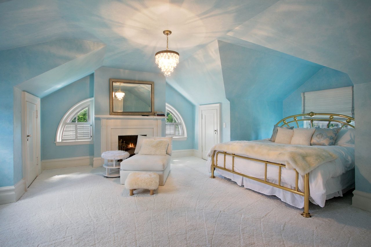 Third floor bedroom, fully carpeted with 4 over-sized closets for storage and a fireplace.