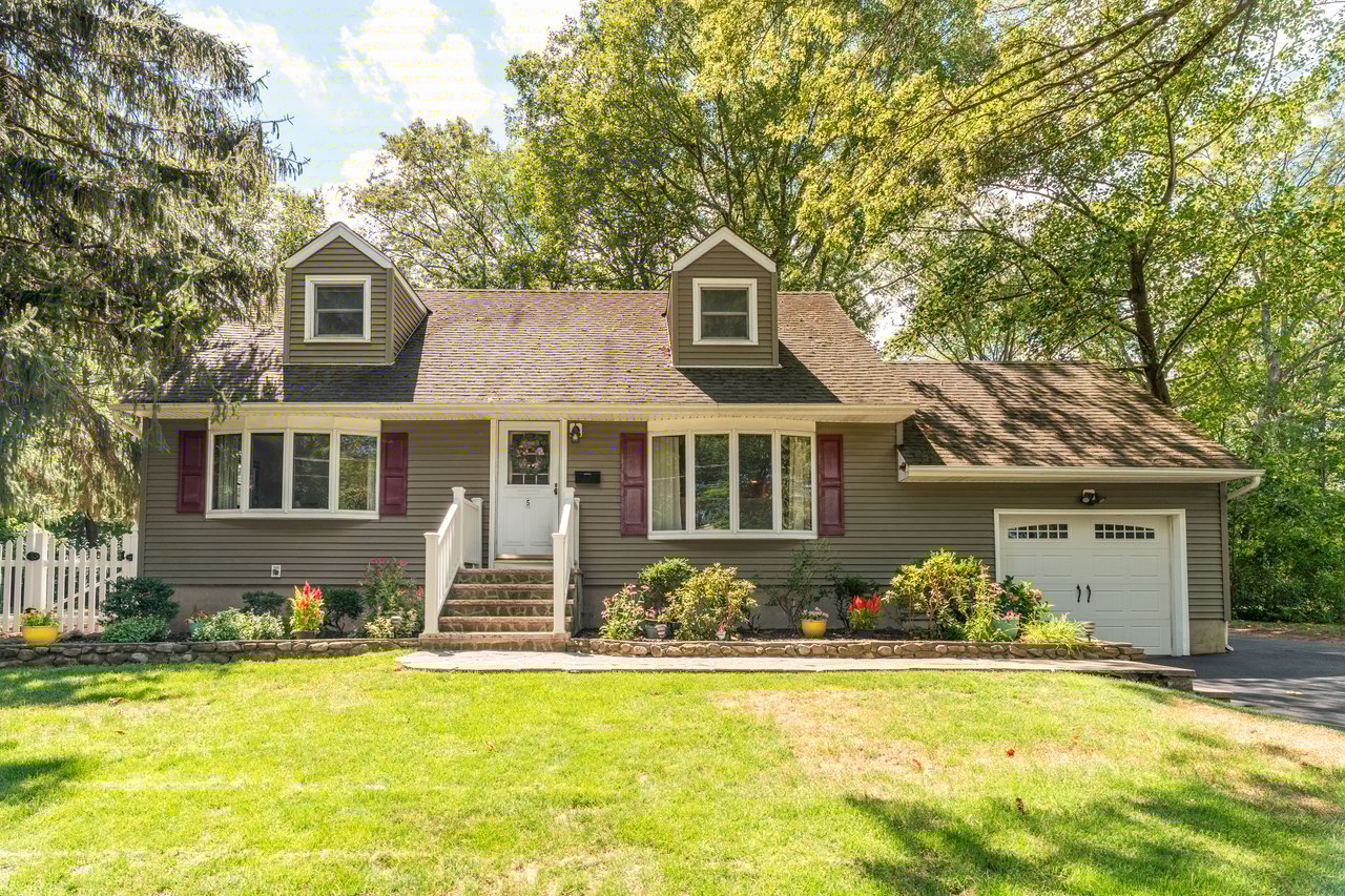 Cape cod house featuring an attached garage.