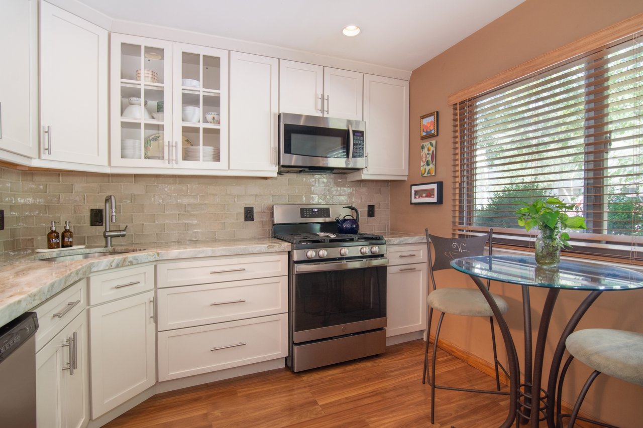 Kitchen with appliances with stainless steel finishes, white cabinets.