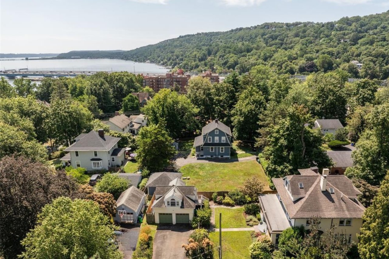 Aerial perspective of suburban area with a large body of water and a heavily wooded area