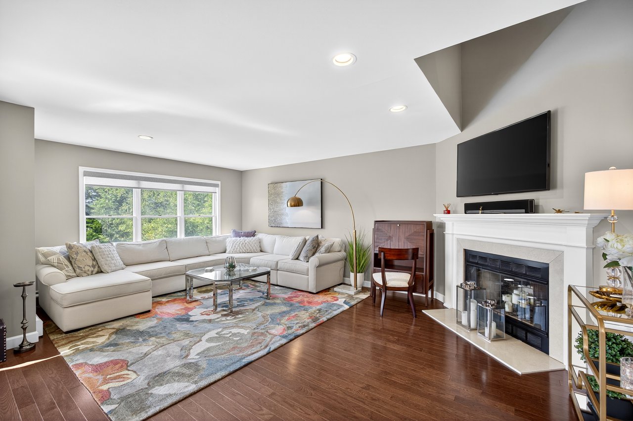 Living room featuring wood finished floors, recessed lighting, and fireplace.