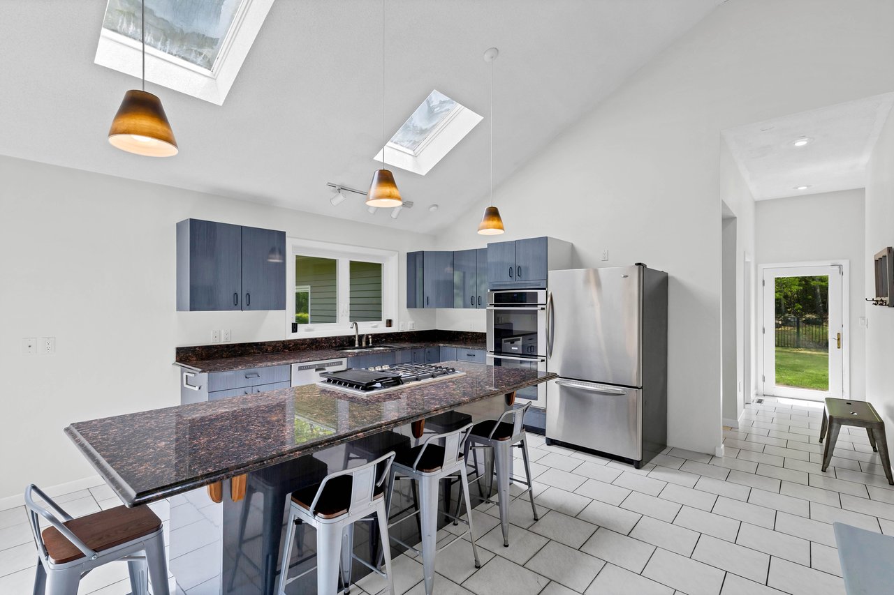 The kitchen and heart of the home. featuring granite counters, 5 burner gas stove top and lots of natural lighting