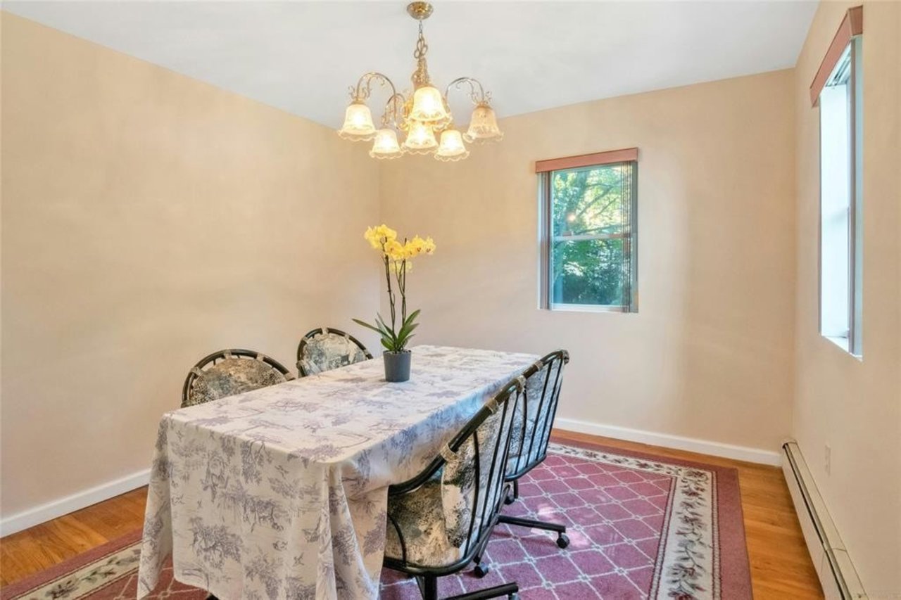 Dining room with chandelier and two windows.