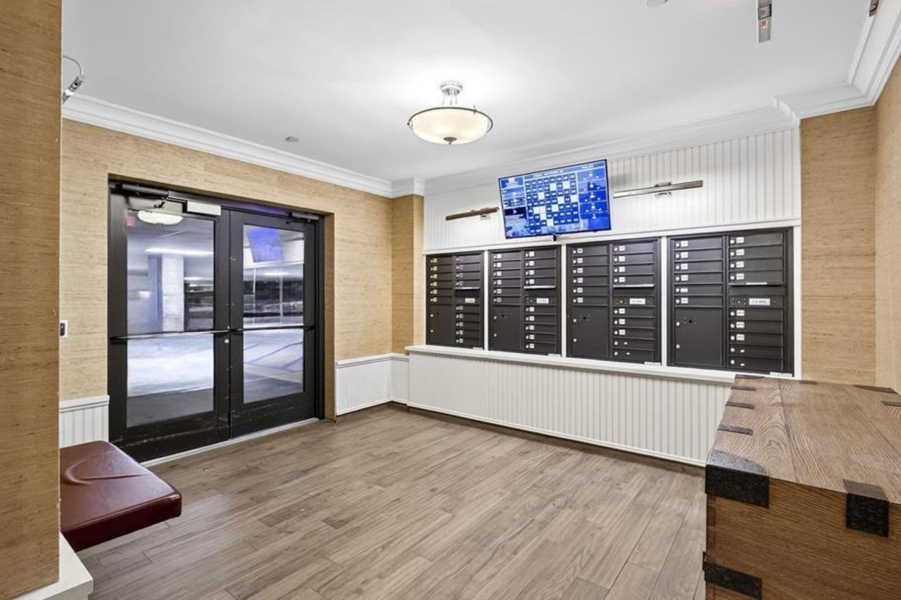View of home's community with mail area, crown molding, a wainscoted wall, and wallpapered walls...