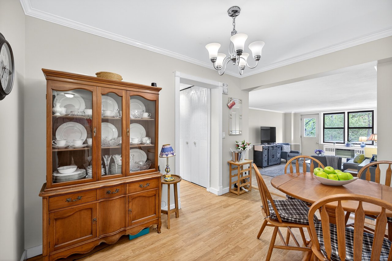 Dining space featuring crown molding, light wood-type flooring, and a chandelier