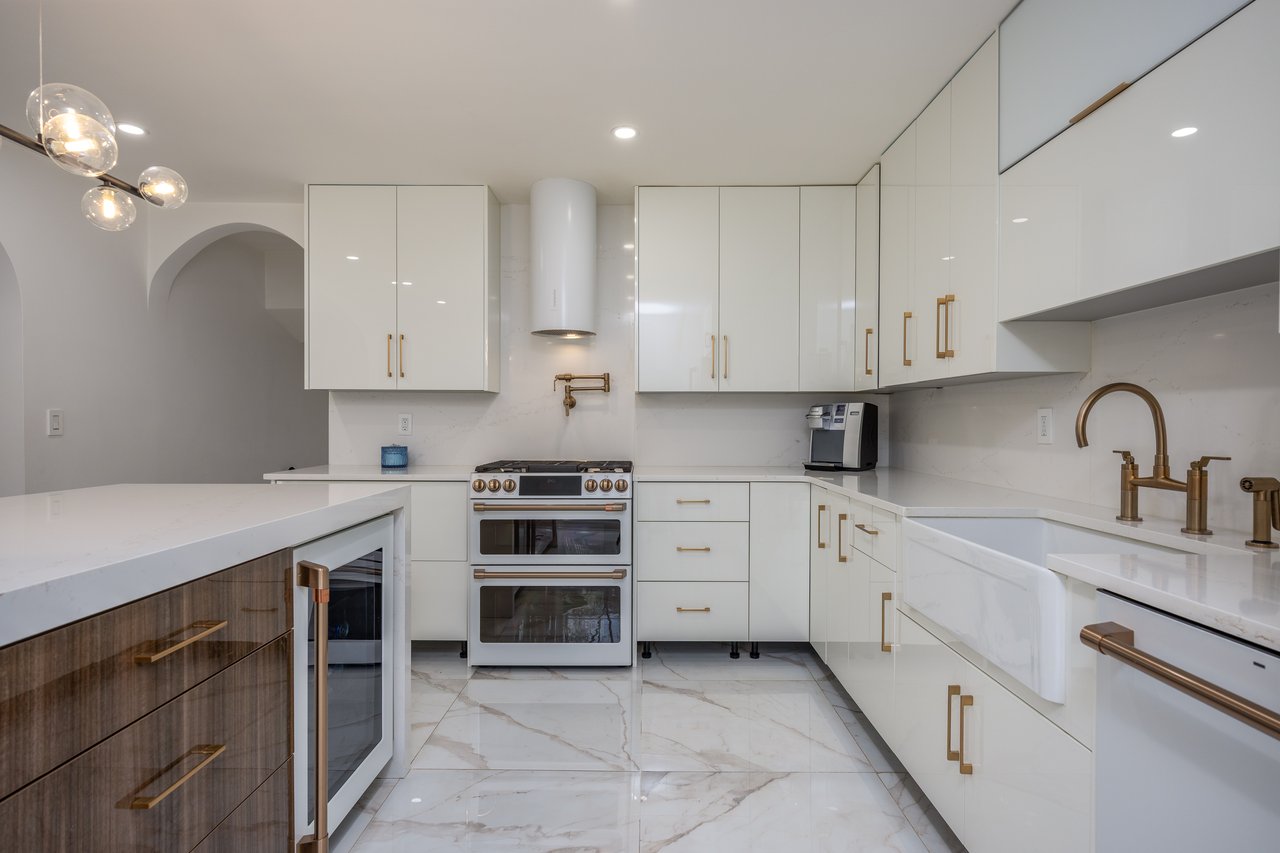 Kitchen featuring white cabinetry, modern cabinets, white appliances, light stone countertops, and recessed lighting...