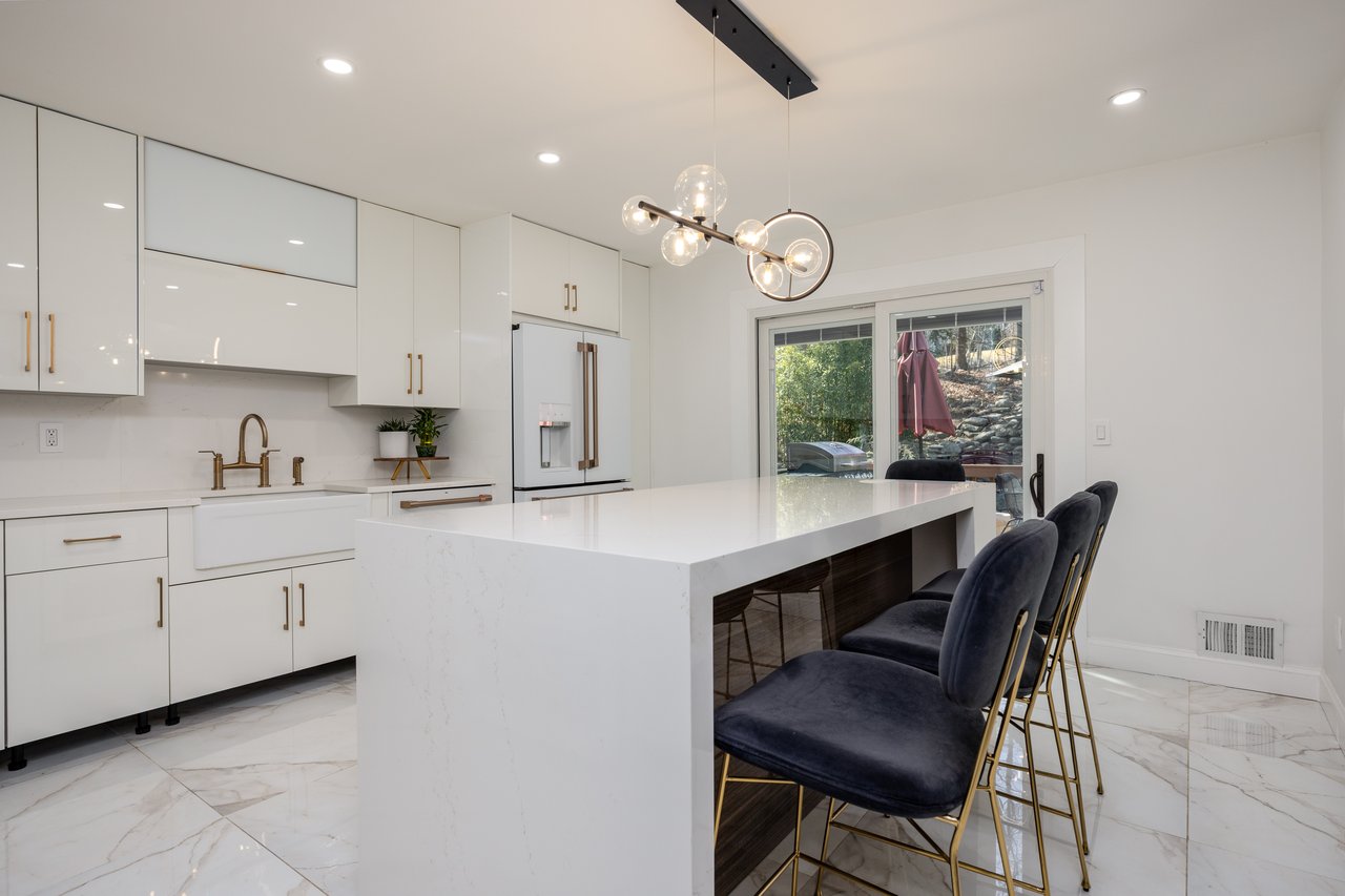 Kitchen with light marble finish floors, white cabinetry, modern cabinets, recessed lighting, and pendant lighting...