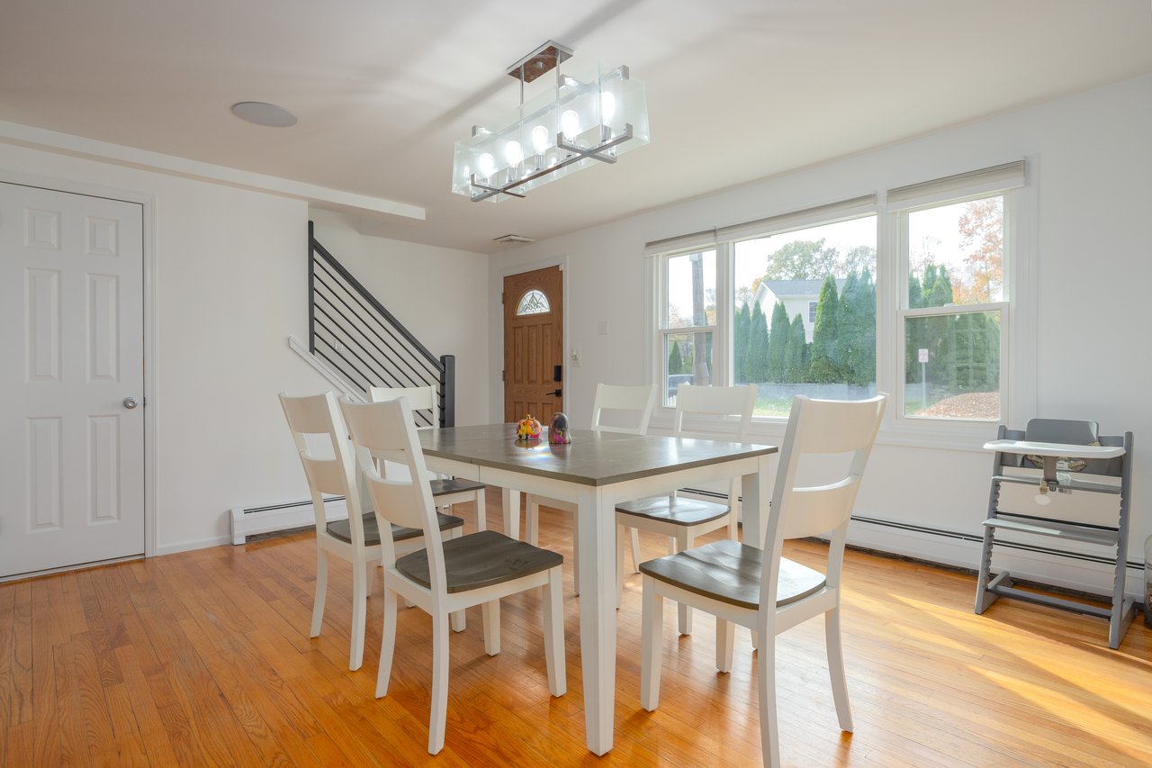 Dining area featuring light wood finished floors, stairway, baseboard heating, and a chandelier