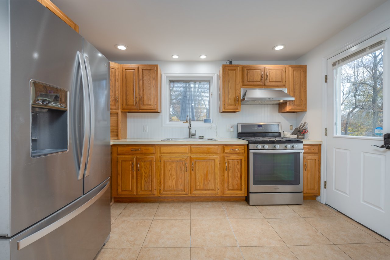Kitchen featuring appliances with stainless steel finishes, light countertops, light tile patterned floors, under cabinet range hood, and recessed lighting