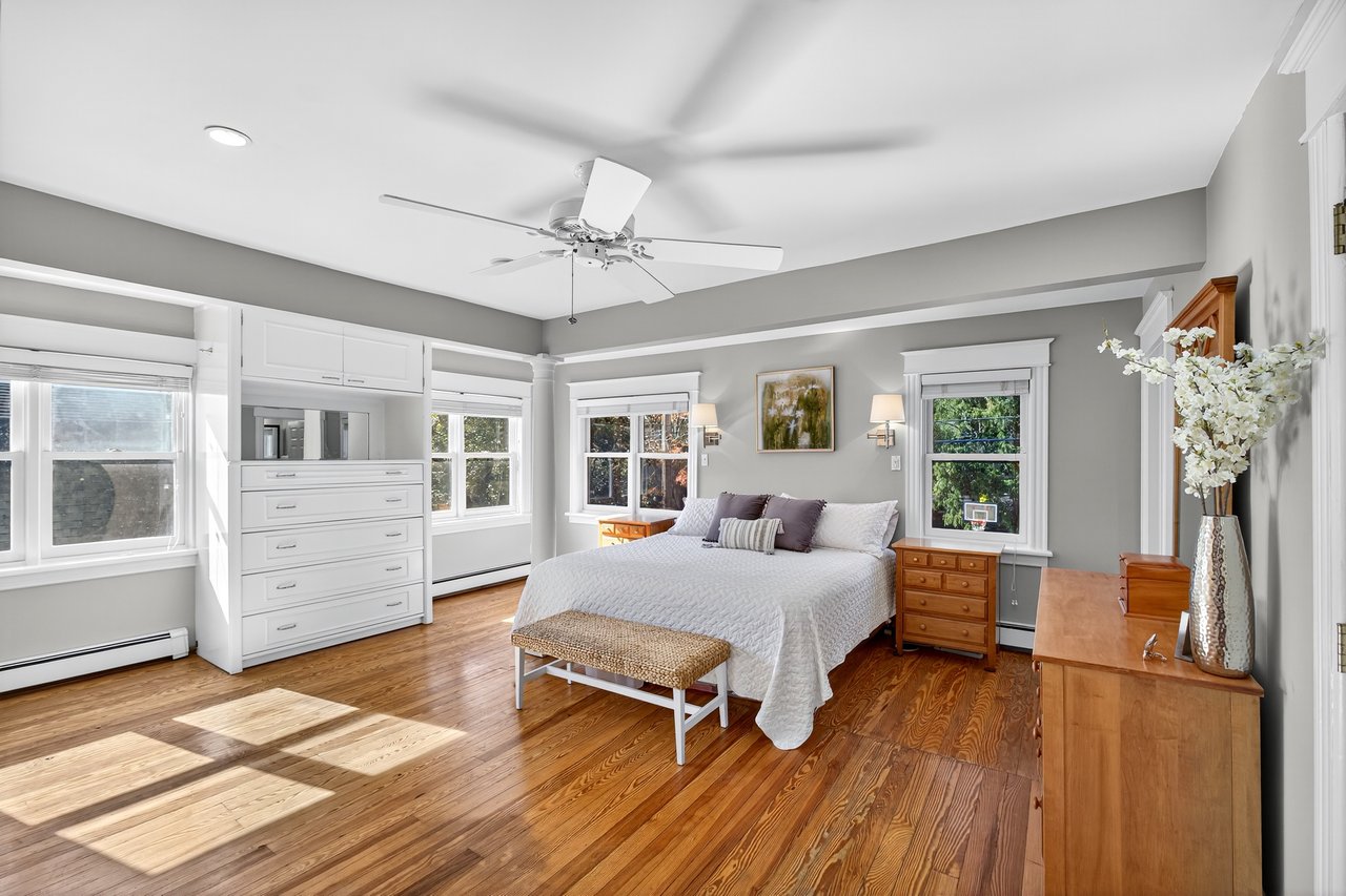 Generous Primary Bedroom with hardwood floors, built-ins and en suite bathroom