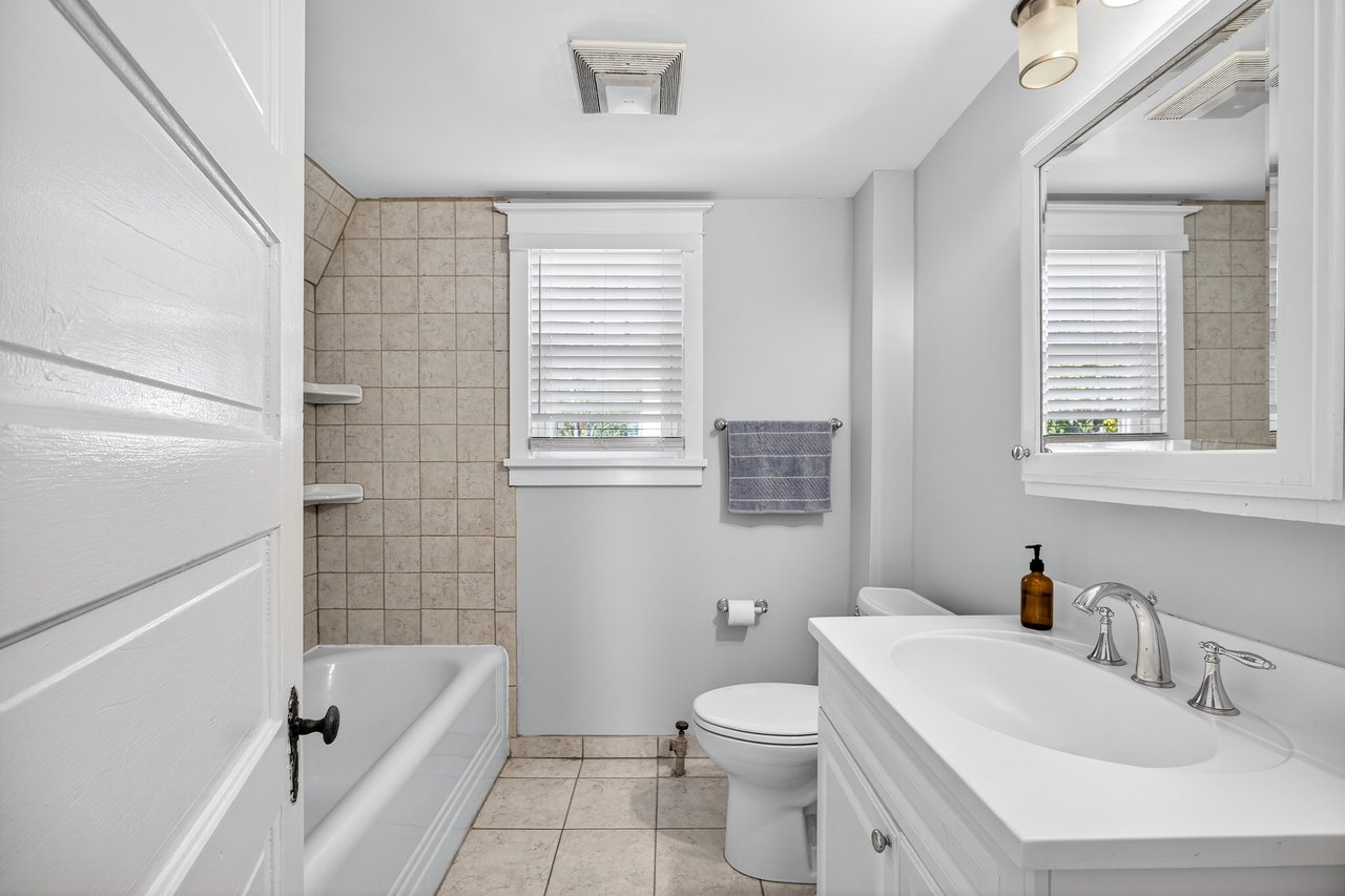 Full bathroom featuring vanity, light tile patterned floors, and bathtub / shower combination with additional storage