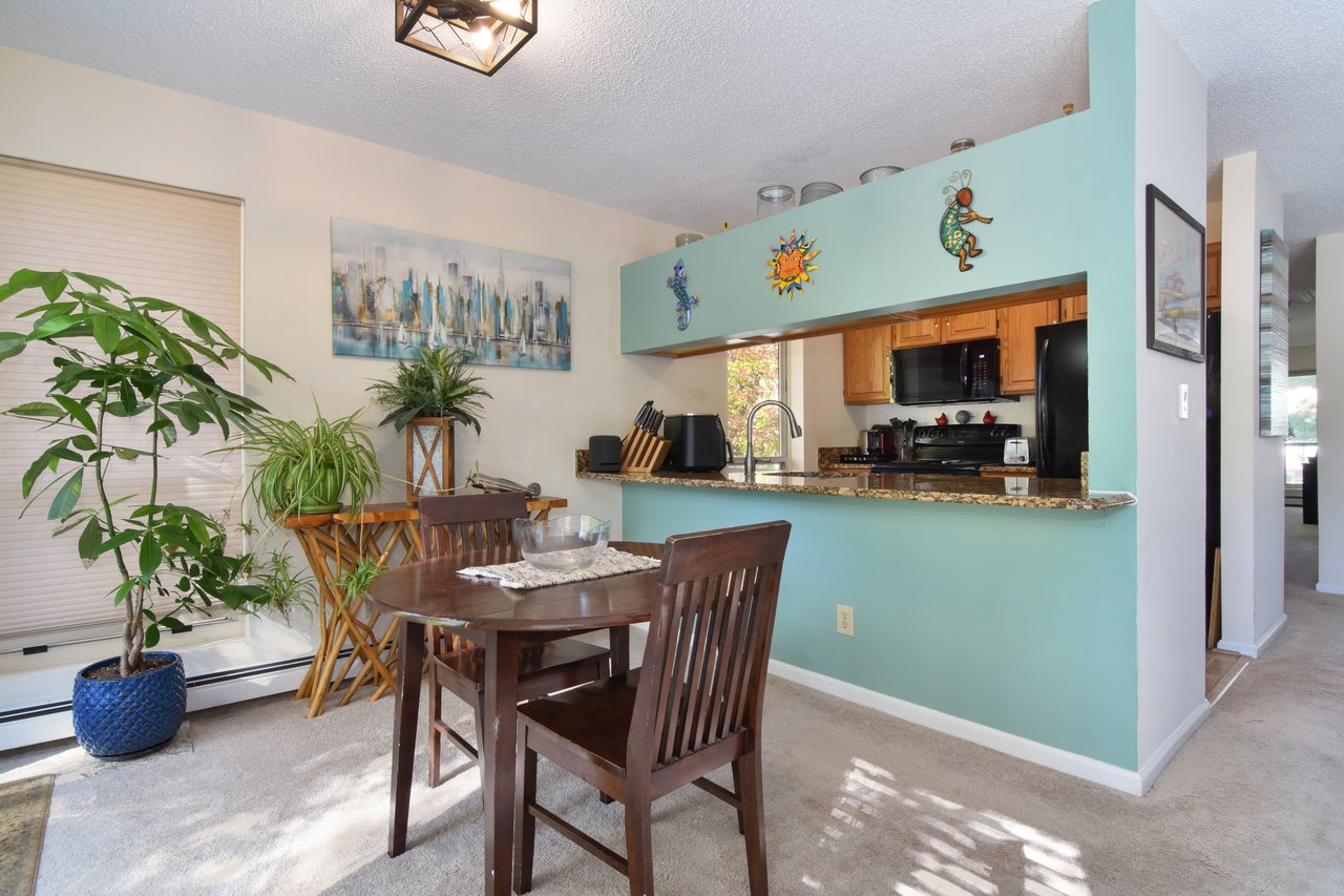 The dining space flows naturally into the kitchen, highlighted by a granite breakfast bar for added convenience and style.