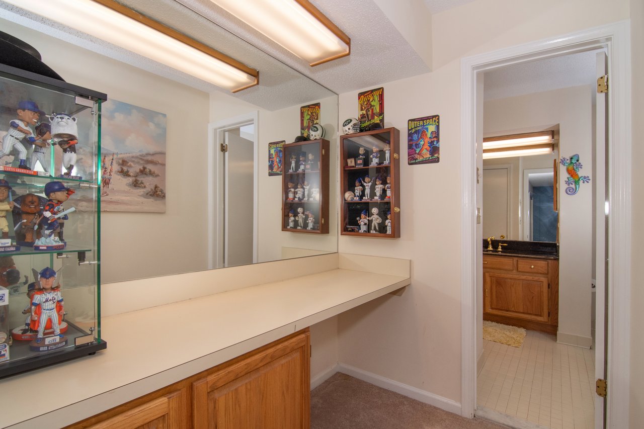 This dressing area provides additional storage plus a designated area for a chair and vanity setup.