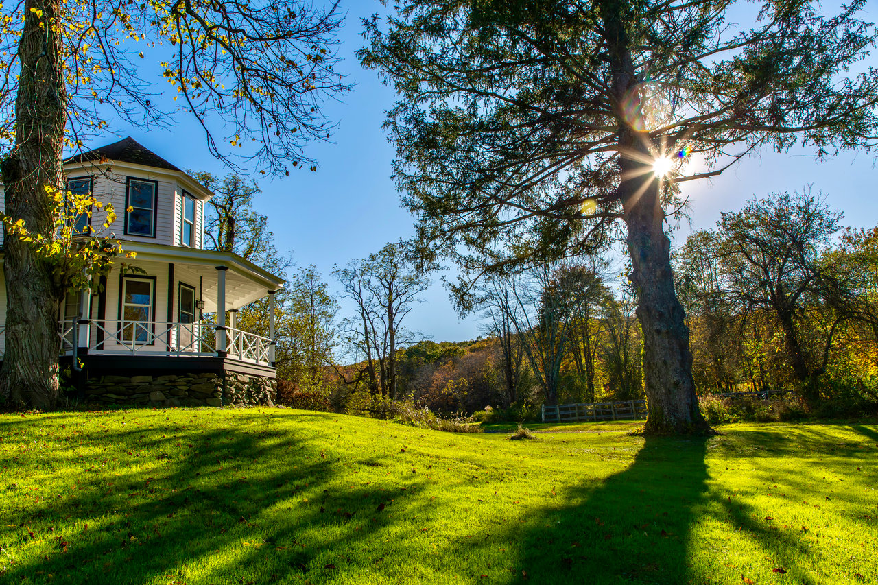 View of green lawn featuring covered porch