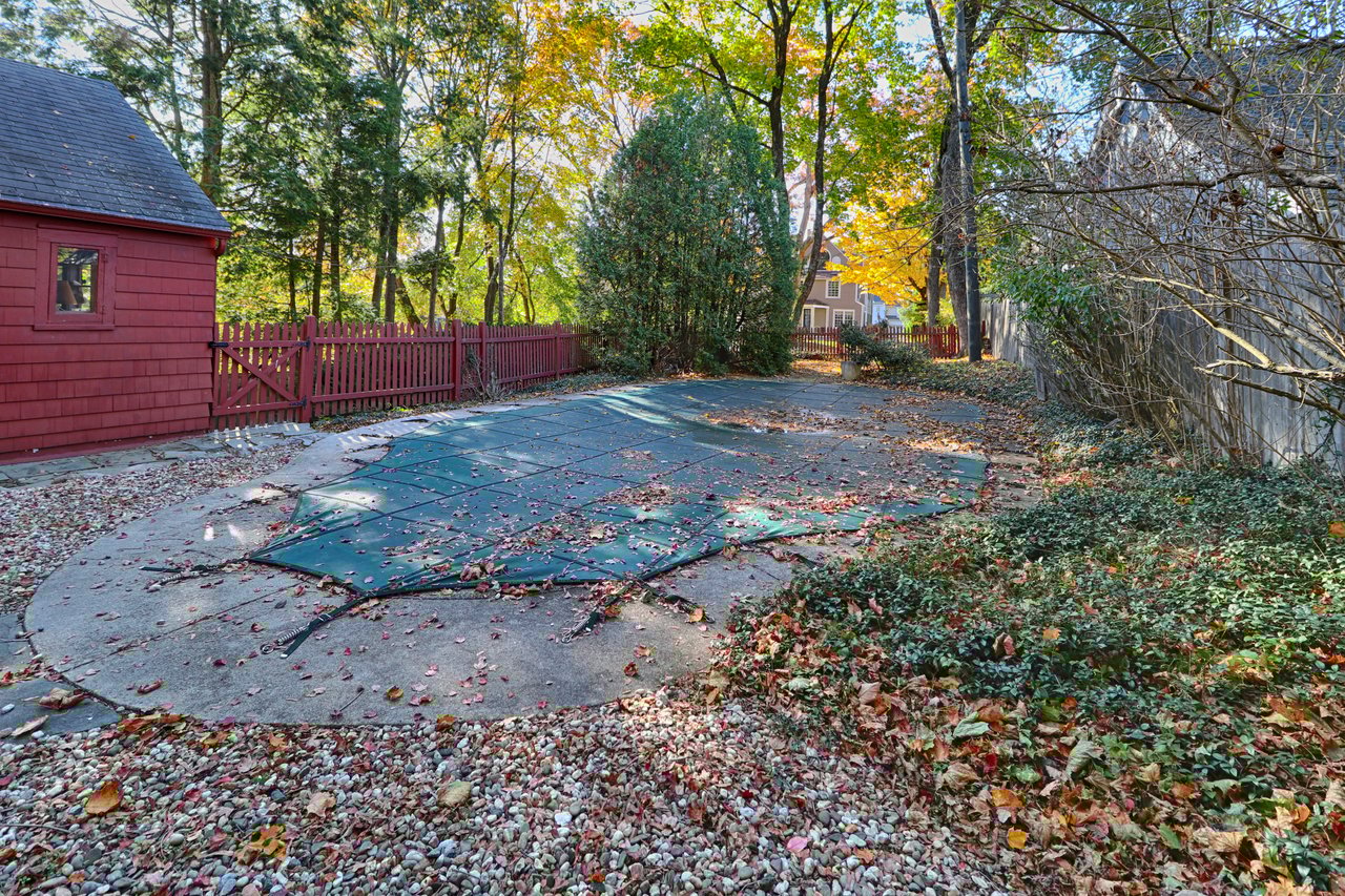 There is a stone patio by the pool.