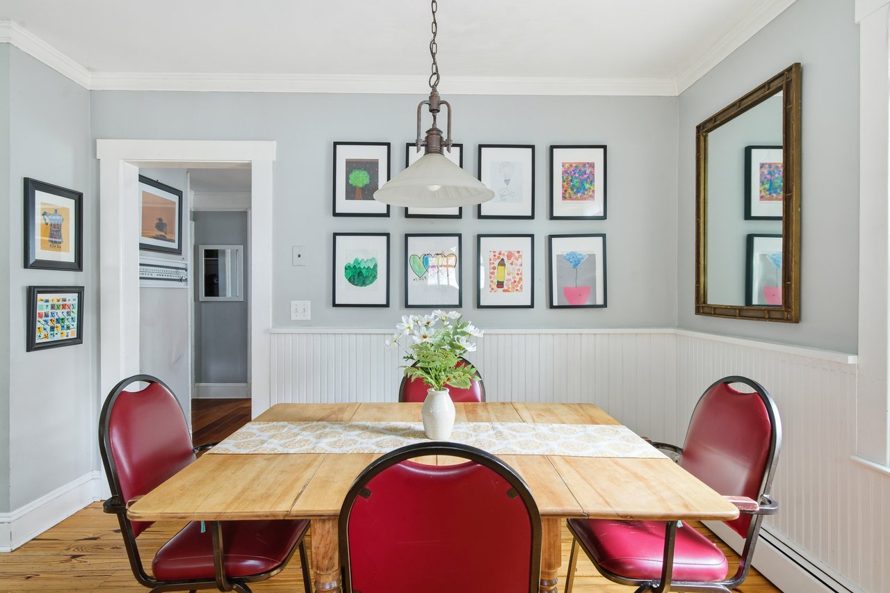 Dining space with wood finished floors, crown molding, and baseboard heating