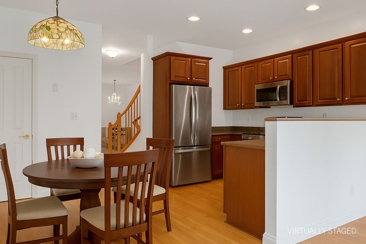 Kitchen featuring brown cabinetry, stainless steel appliances, pendant lighting, recessed lighting, and light wood-style floors