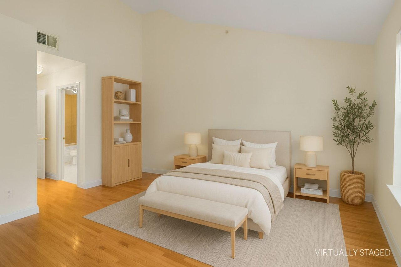 Virtually staged spare room with vaulted ceiling and light wood flooring